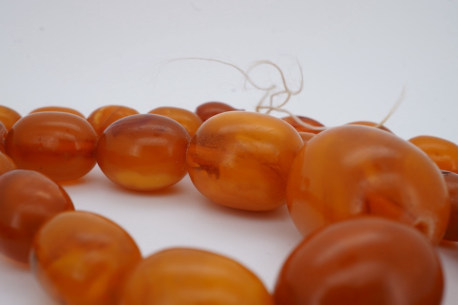 A single strand graduated oval amber bead necklace, 66cm, gross weight 63 grams. Condition - poor to fair